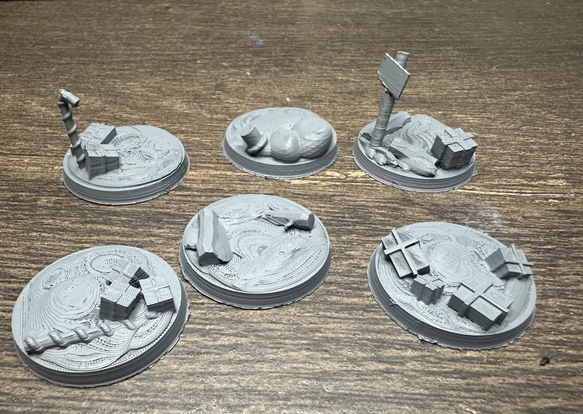 All five 28mm Christmas bases primed grey showing sculpted detail