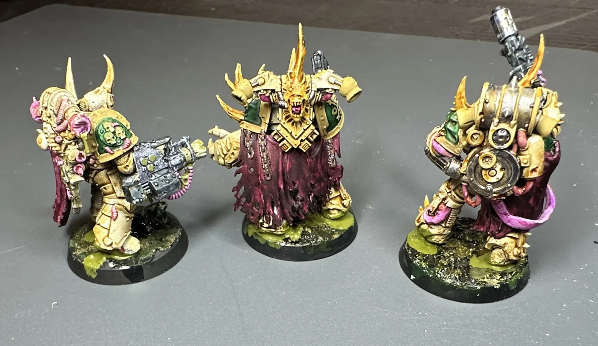 Three Plague Marines from behind showing Murder Scene Red capes and green shoulder panels